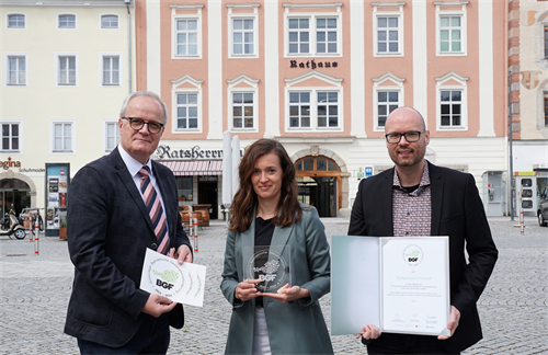 Bürgermeister Christian Gratzl, Stadtamtsleiter Florian Riegler und Projektleiterin Sabrina Auböck vor dem Rathaus mit dem Gütesiegel in der Hand