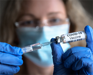 Das Bild zeigt eine Frau mit einer Impfnadel für Covid.