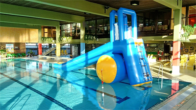 Das Bild zeigt das große Schwimmbecken mit Wasserrutsche.