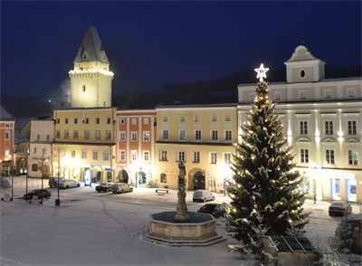Das Bild zeigt den verschneiten Hauptplatz mit dem Christbaum