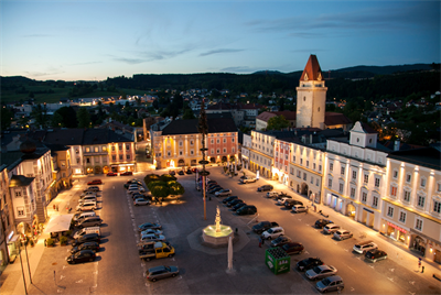 Der beleuchtete Hauptplatz von Freistadt in der Abenddämmerung.